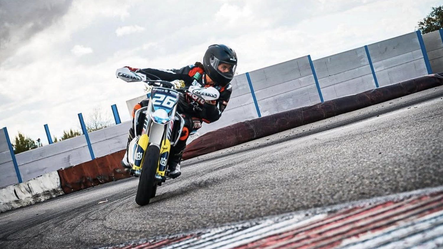 Pit bike inclinada apurando la curva en el circuito