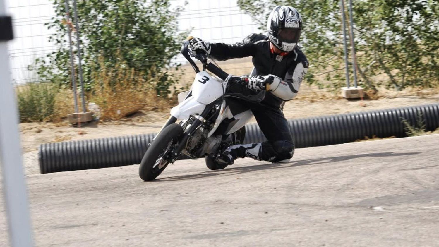Supermotard inclinado en una curva del circuito