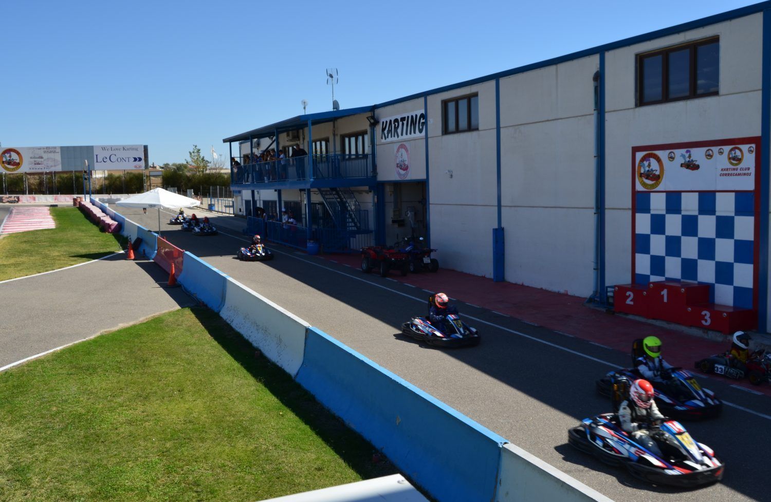Karts rodando frente a boxes y podio